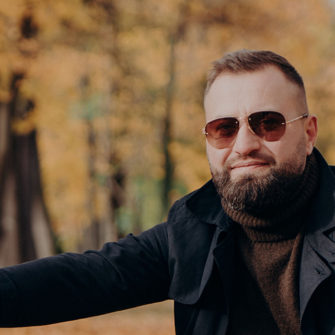 Bearded man in front of autumn leaves